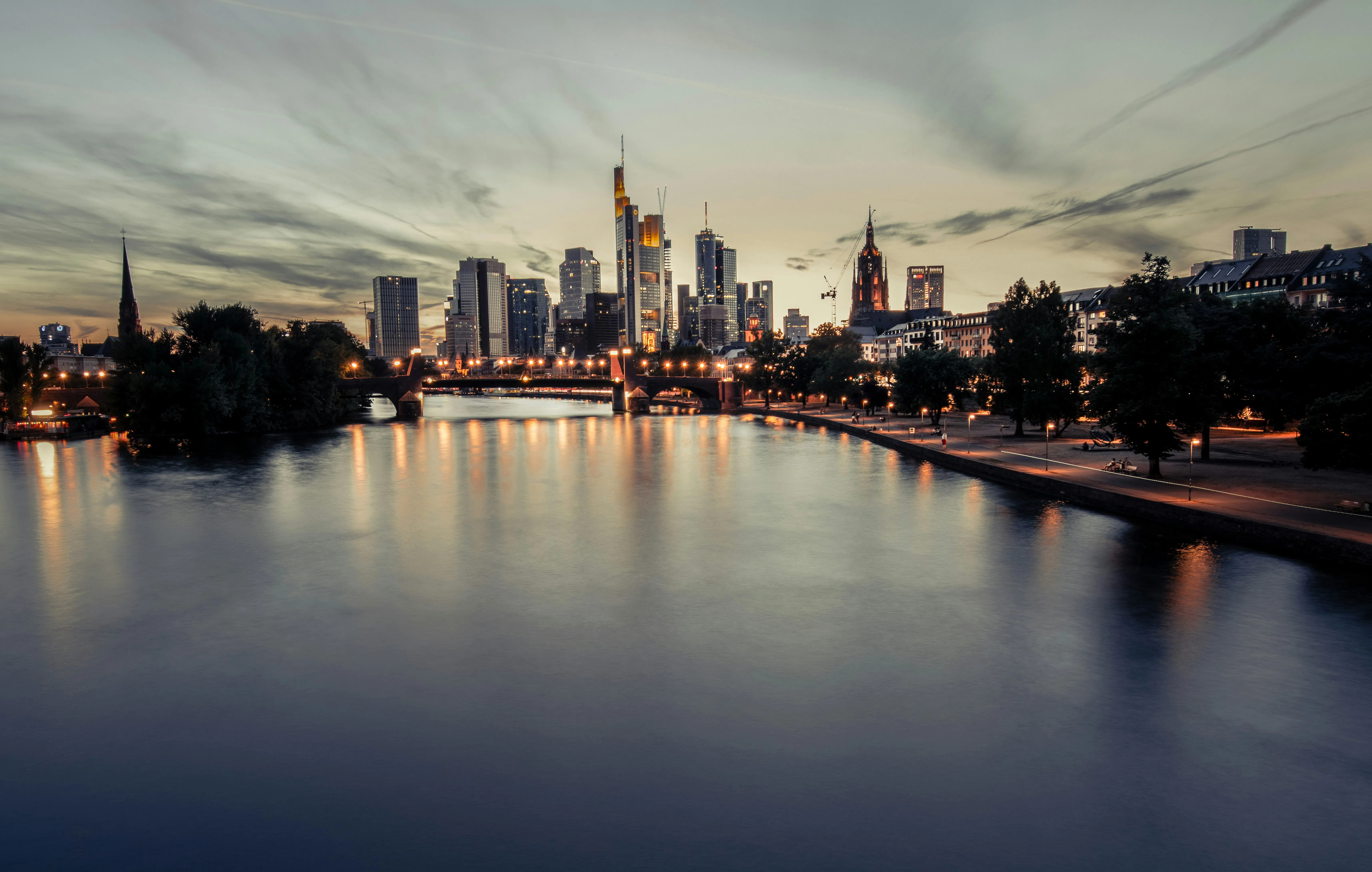 Der Main am Abend, dahinter die Frankfurter Skyline und der Kaiserdom